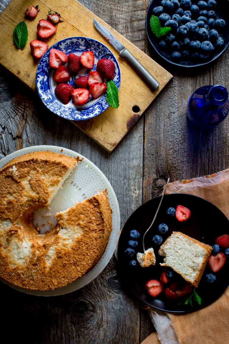 Overhead shot of Healthy Angel Food Cake next to blueberries and strawberries 