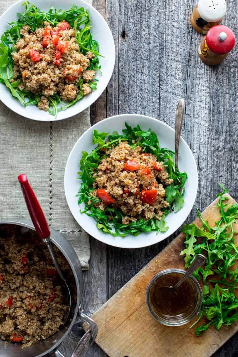 Two bowls with Warm Quinoa Arugula Salad on a table