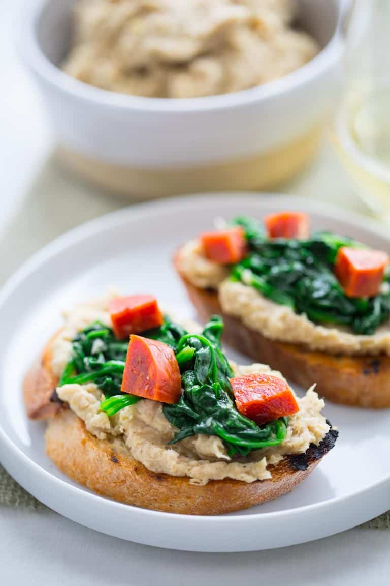 White Bean Bruschetta with Garlicky Greens on a serving plate 