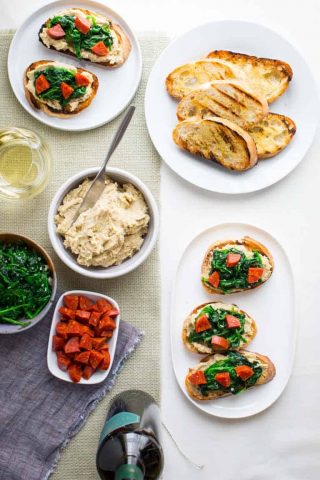 These super versatile and yummy White Bean Bruschetta with Garlicky Greens are the perfect little appetizer for your Spring and Summer get-togethers. | Healthy Seasonal Recipes | Katie Webster