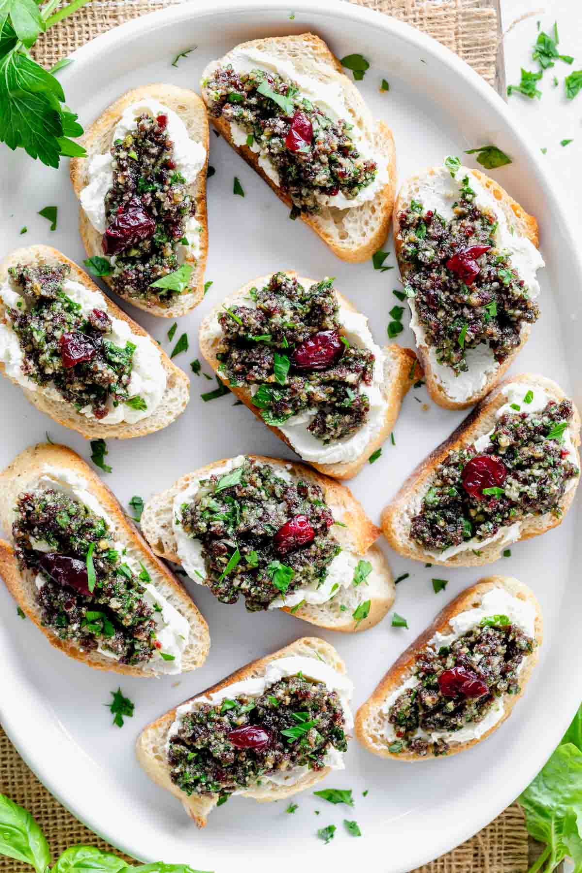 the crostini on a white platter with chopped parsley