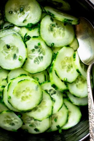 close up of cucumber salad in a black bowl