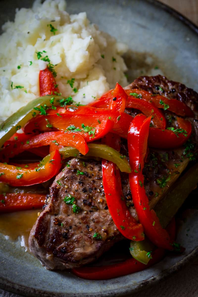 Skillet Pepper Steaks with mashed potatoes alongside 