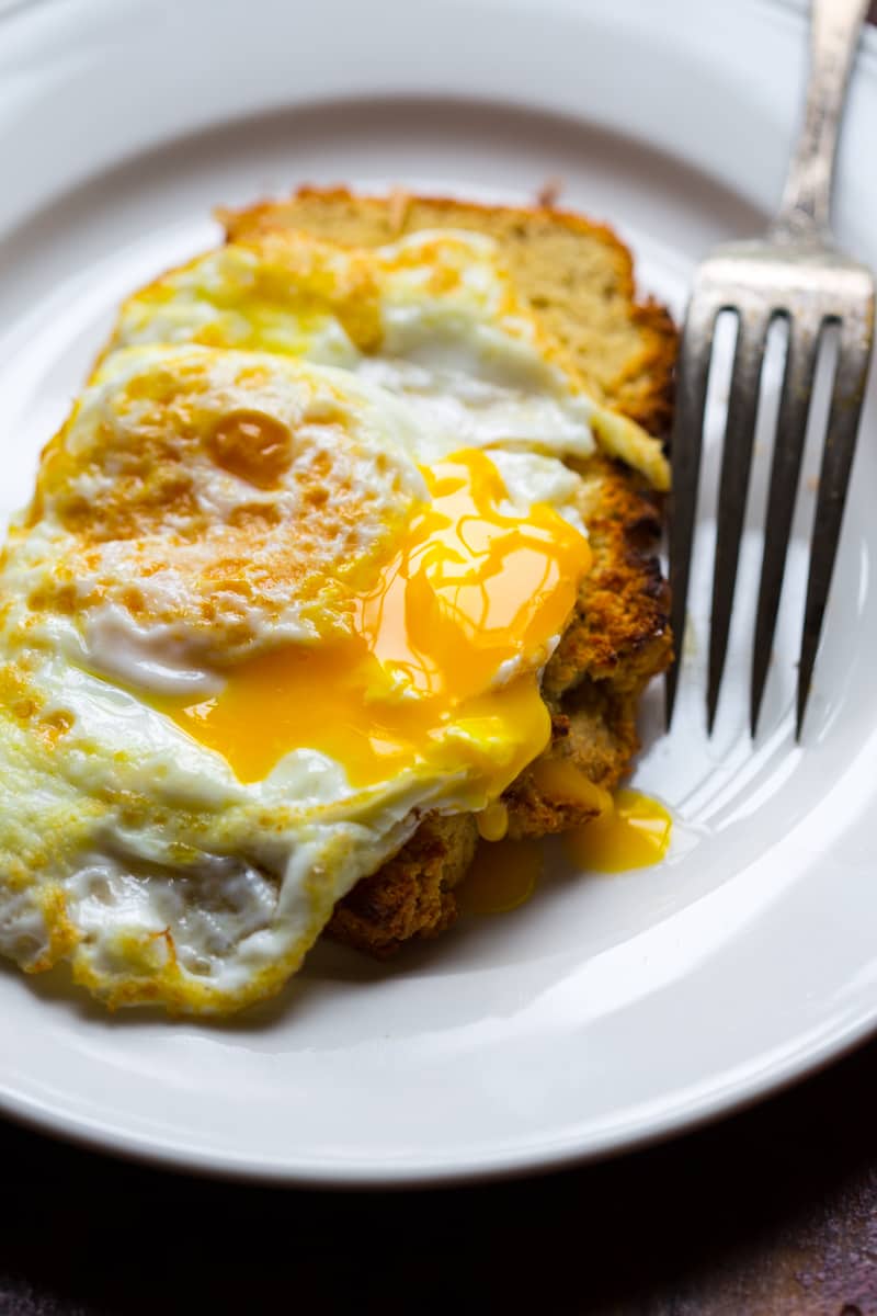 a slice of gluten free quick bread with a fried egg on top 