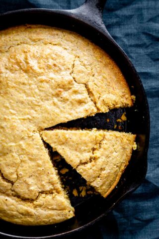 overhead of the cornbread in the skillet with a wedge cut