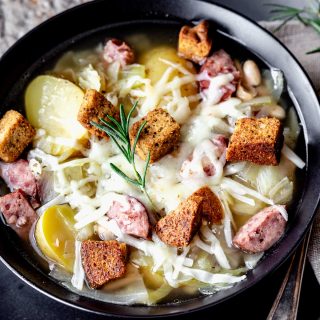 kielbasa and cabbage soup in black bowl