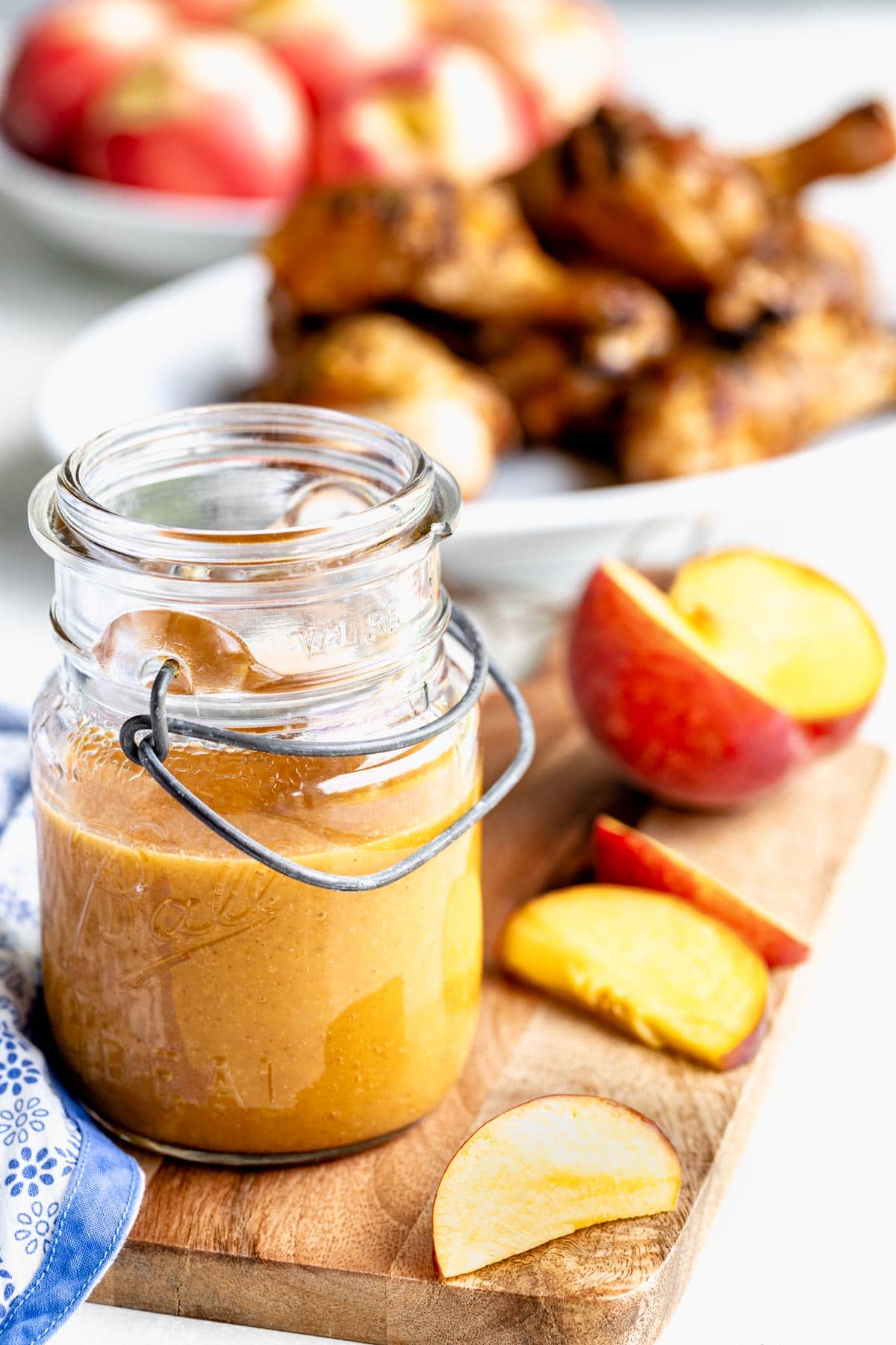 maple syrup barbecue sauce in a jar beside fresh peaches