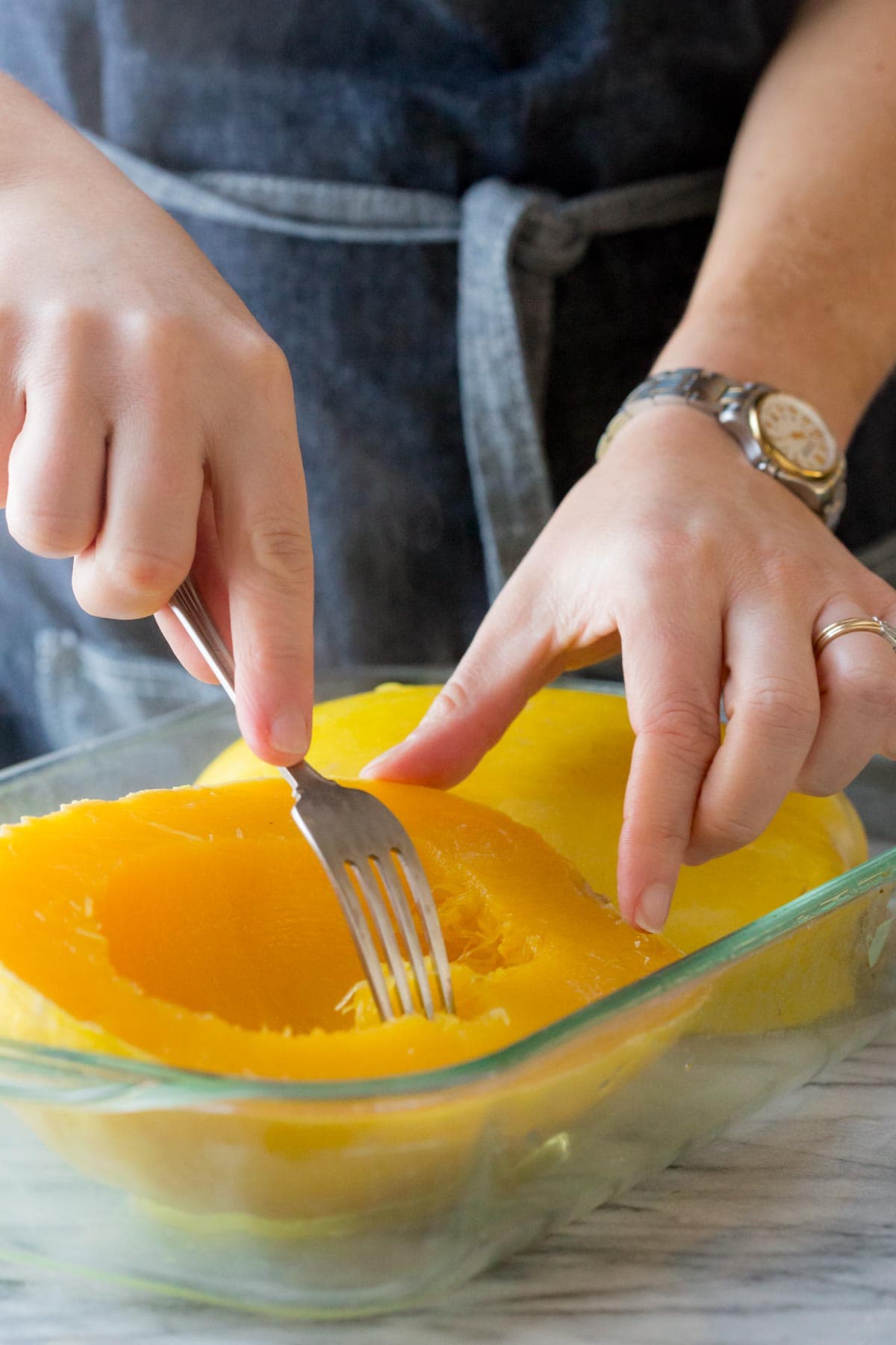testing how tender the squash is with a fork
