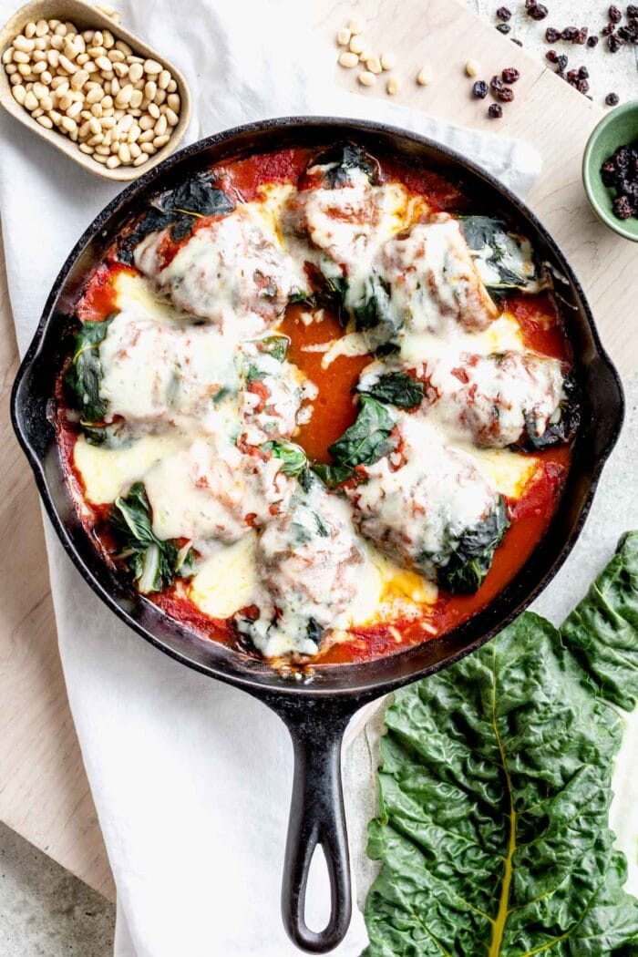 a skillet with swiss chard rolls in it from overhead