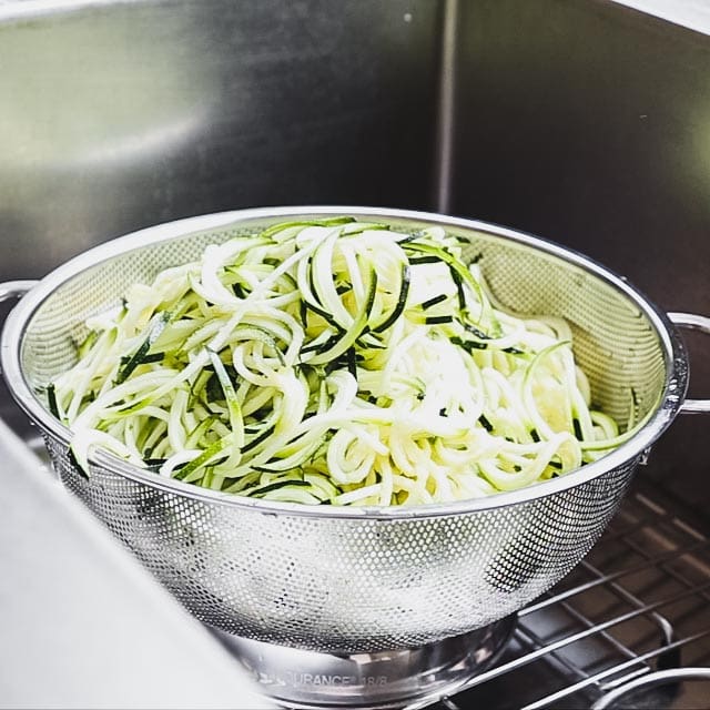 zucchini noodles in a colander.