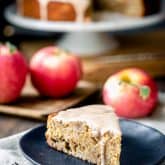 Apple cake slice with maple icing drizzling down the side