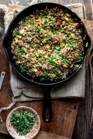 a skillet with lentils with parsley on top