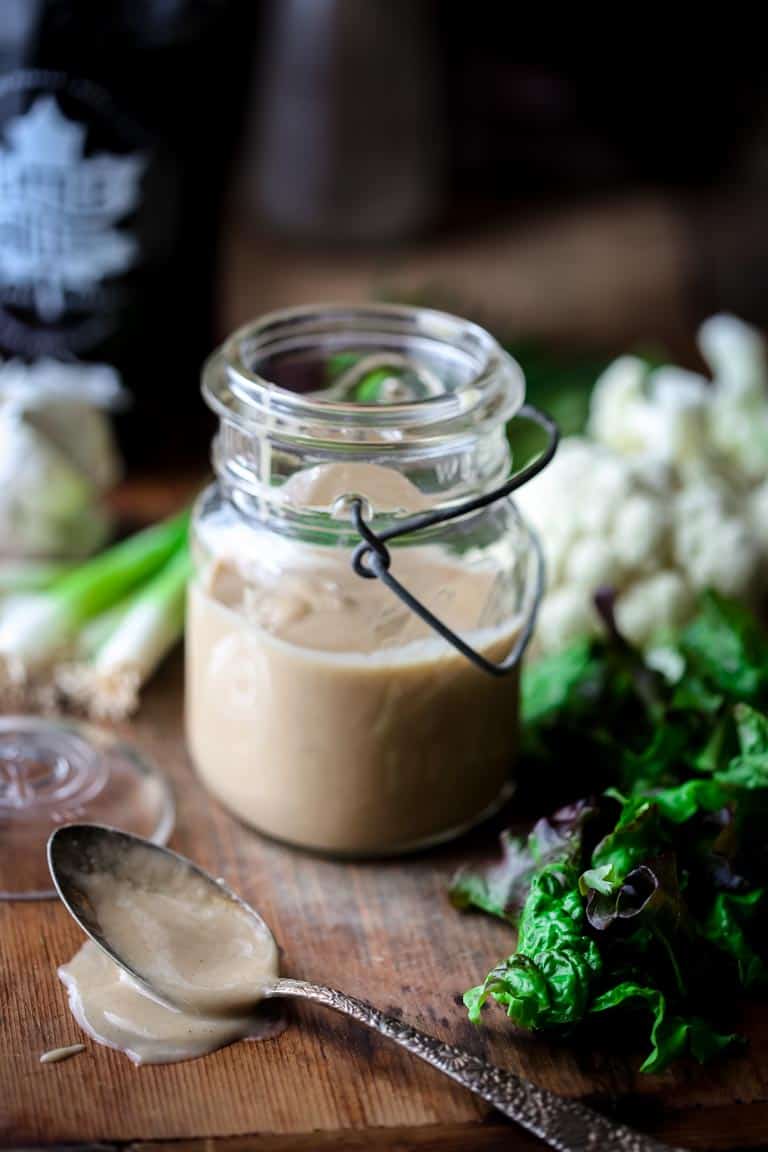 Maple Tahini Dressing in a jar with a spoon