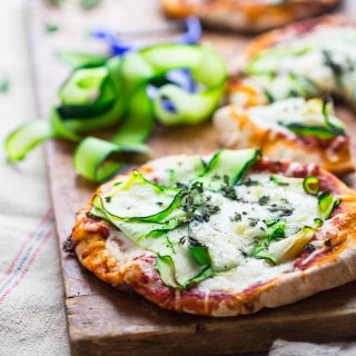 These 20 minute Zucchini Ribbon Pita Pizzas are a super fast, vegetarian weeknight meal that is also kid friendly. They will be making a regular rotation throughout zucchini season! | Healthy Seasonal Recipes | Katie Webster