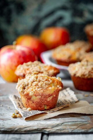 side view of apple muffins with apples in the background
