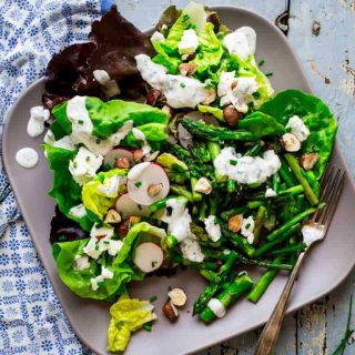 Roasted asparagus, chopped hazelnuts and fresh goat cheese bring staying power to these hearty spring entrée salads. They’re naturally gluten-free and vegetarian. Healthy Seasonal Recipes by Katie Webster | #glutenfree #vegetarian #entreesalad #asparagus #goatcheese