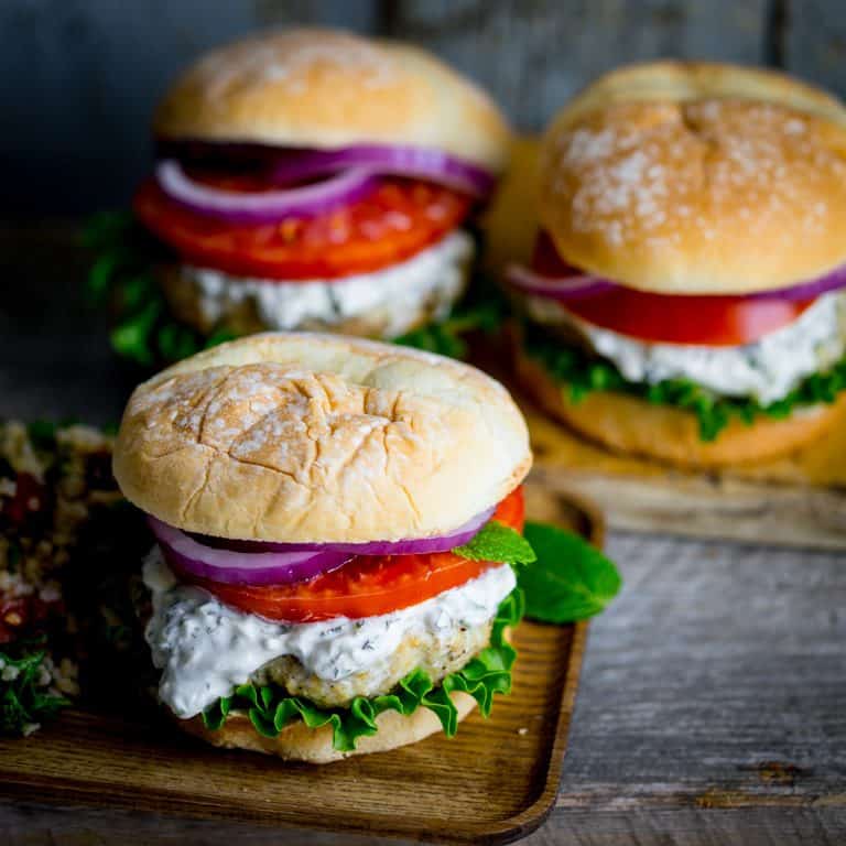 Burgers made from ground chicken, seasoned with za’atar and topped with cucumber mint tzatziki, lettuce and tomato! Get those grills fired up my friends! They’re a middle-eastern flavored burger mash-up you won’t want to miss. Healthy Seasonal Recipes by Katie Webster | #burger #tzatziki #chicken #cucumber #mint #zaatar #grill