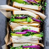 a pan stacked with turkey avocado sandwich halves