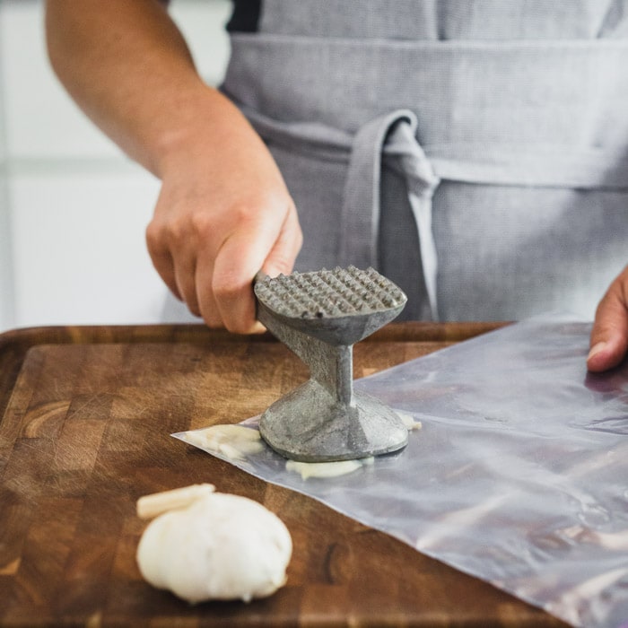 Smash garlic in a resealable bag with the smooth side of a meat mallet