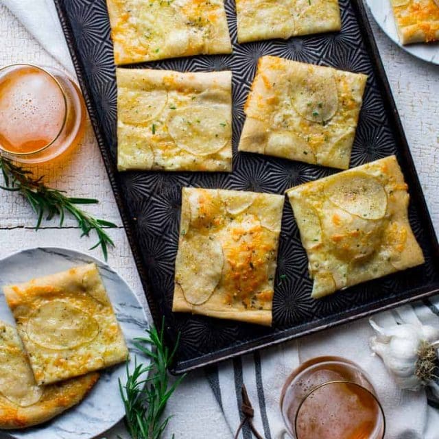 Have you heard of potato pizza before? If not, keep an open mind, and prepare your taste buds for a surprisingly delicious combination. In this white pizza version, I have a bit of rosemary, garlic and cheddar cheese to make it super savory and yummy! #vegetarian #pizza #whitepizza #potato #cheddar