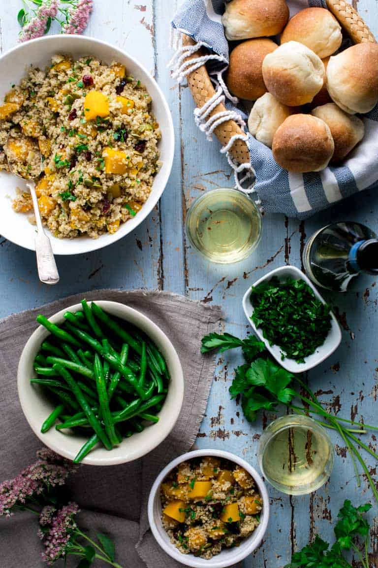 Quinoa Pilaf alongside a basket of rolls and a plate of green beans 