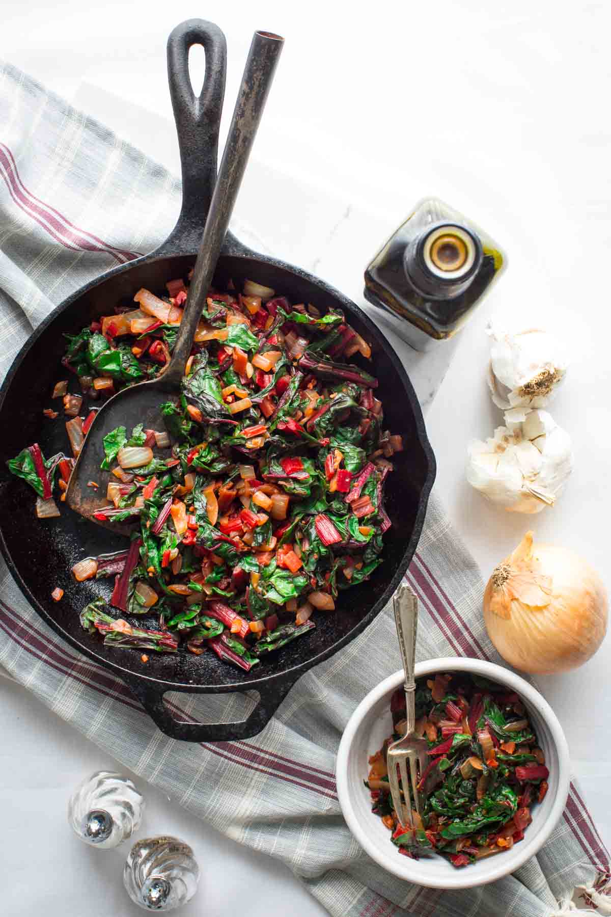 overhead table scape with the skillet and a serving dish with chard in it