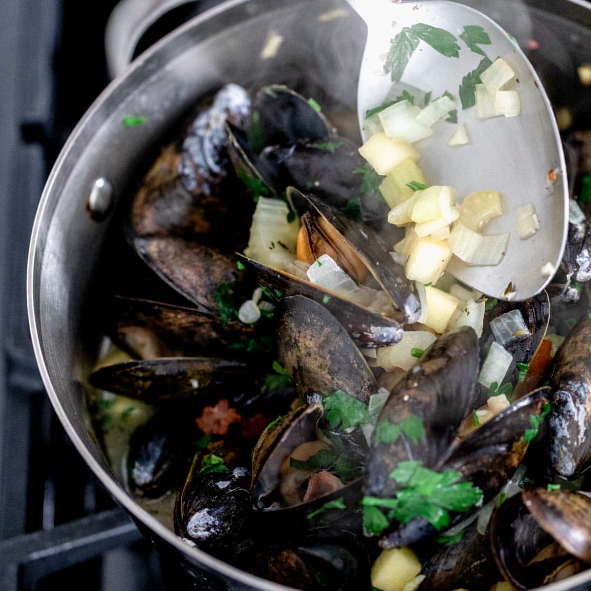 How to Cook Mussels: stir together to coat the cooked mussels in the flavorings and sauce.