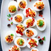 A white platter with spicy deviled eggs on it