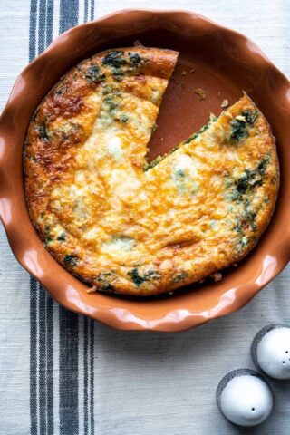 A pie plate with spinach egg bake in it