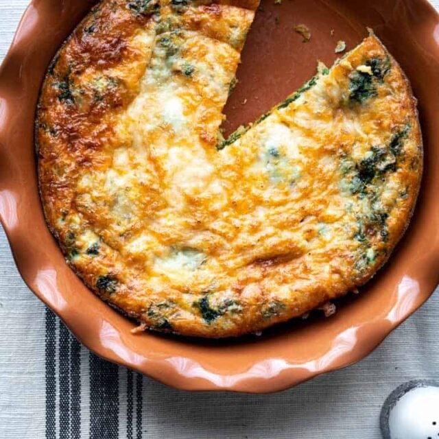 A pie plate with spinach egg bake in it
