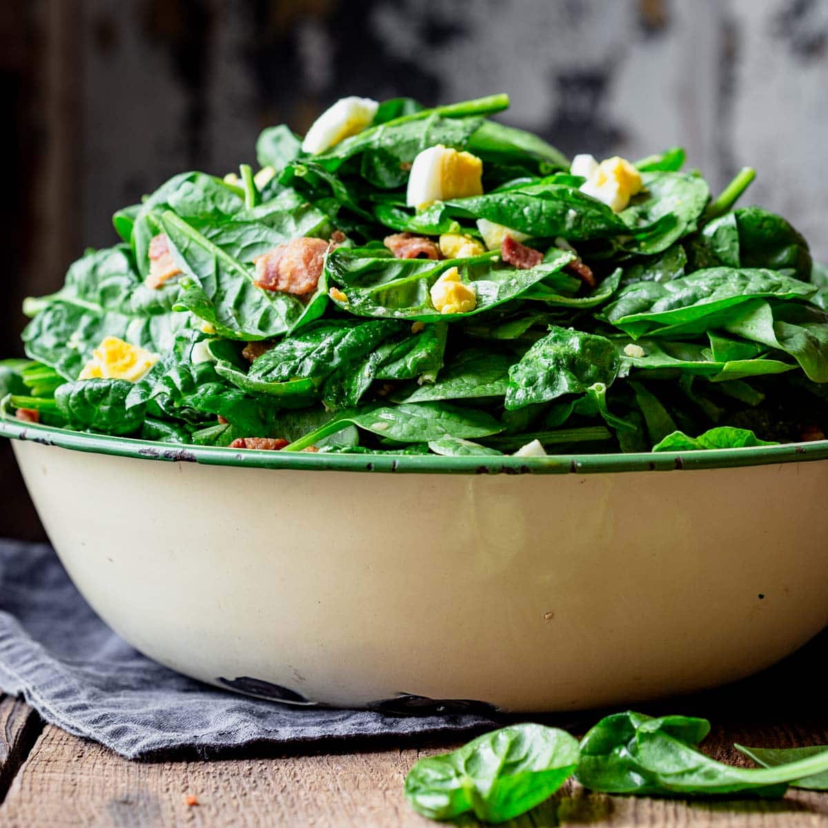 A bowl of salad with Spinach and Bacon