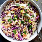 a closeup of the coleslaw with some celery hearts on the table surface