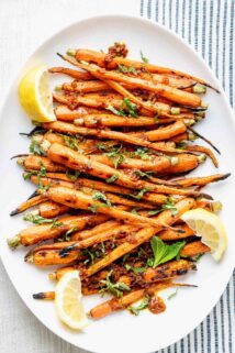 white platter of grilled carrots on a blue and white tablecloth