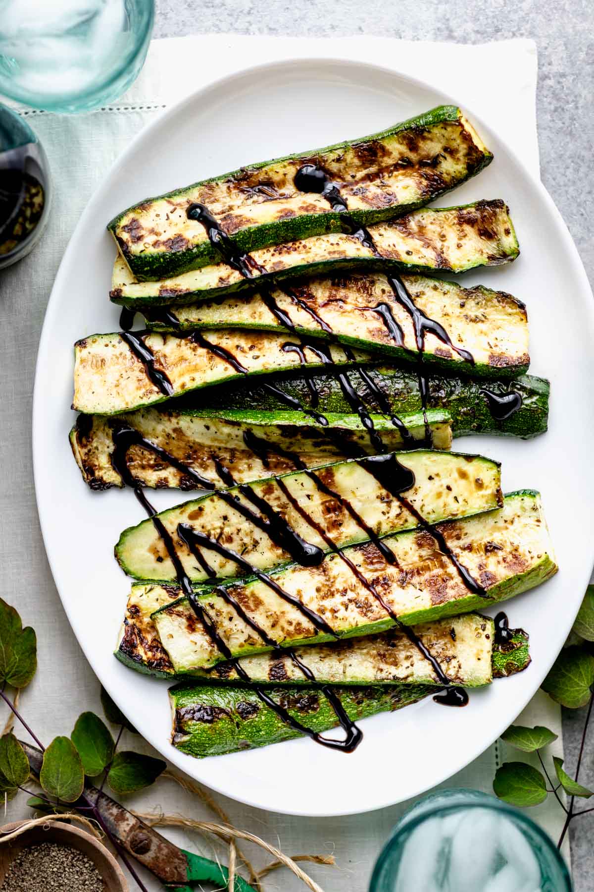 Grilled zucchini from overhead with green scissors, twine and clippings from the garden
