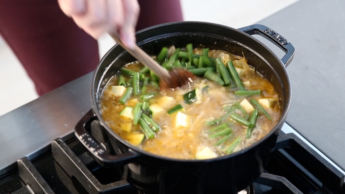 a pot of soup with green beans