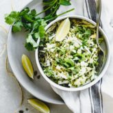 Coleslaw overhead in a single bowl with lime wedges and cilantro