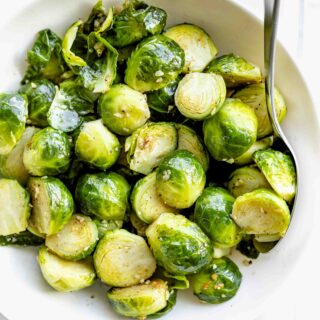 a close up of the steamed brussels sprouts with a spoon