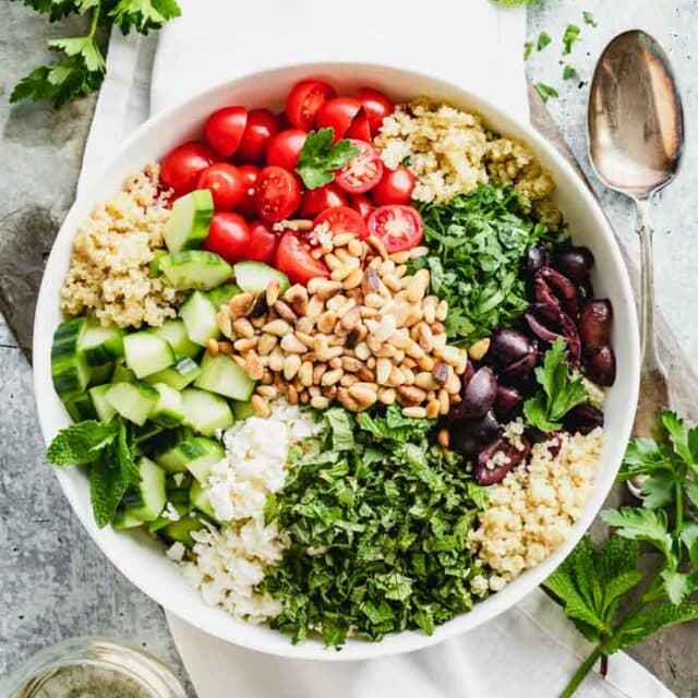 A bowl topped with Mediterranean ingredients