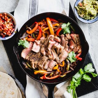 A skillet filled with ingredients for Fajitas and Steak