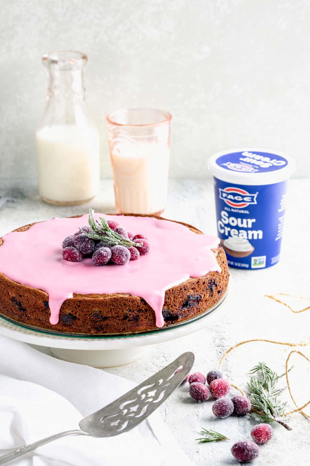 Cranberry cake and a container of FAGE sour cream on a white table