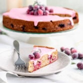 cranberry cake from the side and a slice on the plate