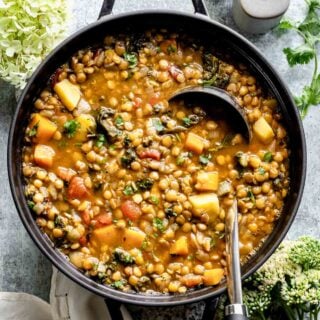 black pot overhead with soup with a ladle