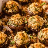 stuffed mushrooms topped with breadcrumbs in a baking dish