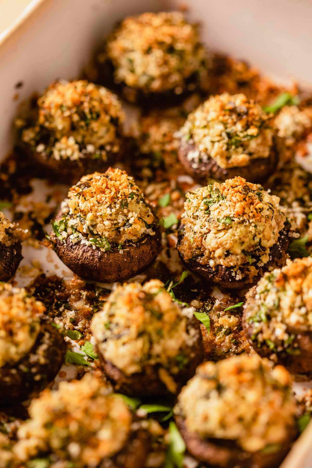 stuffed mushrooms topped with breadcrumbs in a baking dish