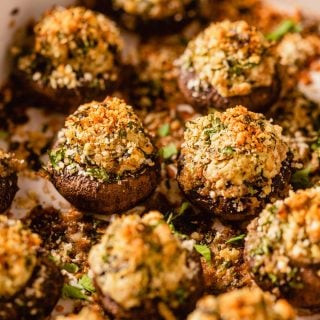 stuffed mushrooms topped with breadcrumbs in a baking dish