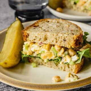 chickpea tuna salad on a white plate with a pickle spear