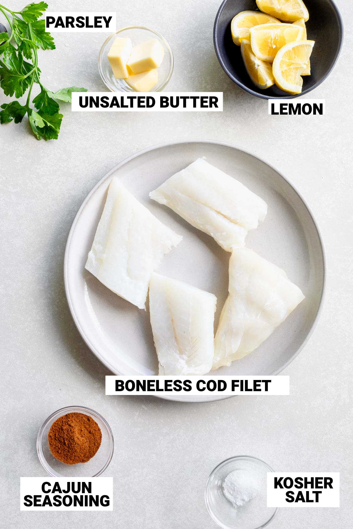 ingredients to make blackened cod including cod fillets, parsley, unsalted butter, lemon, cajun seasoning and kosher salt