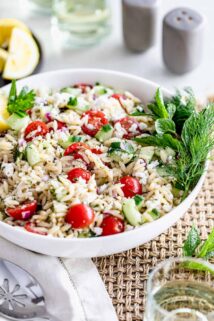 Orzo Pasta salad in a white bowl on a table.