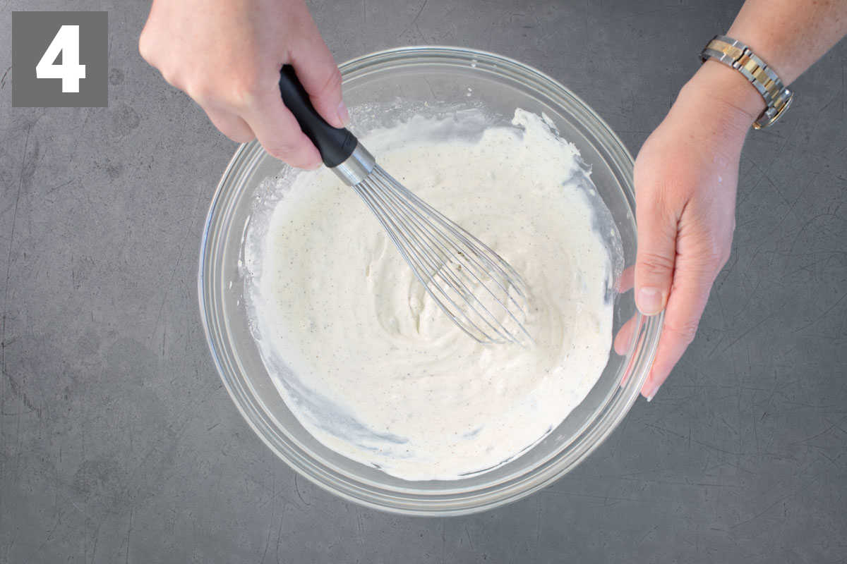 whisking the dressing together in a bowl 