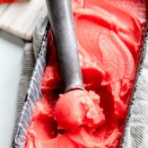 watermelon sorbet being scooped out of a pan